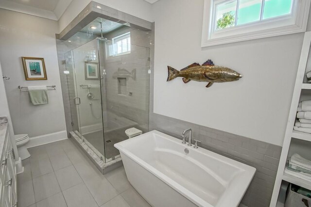 full bathroom featuring baseboards, a soaking tub, a stall shower, tile patterned floors, and toilet