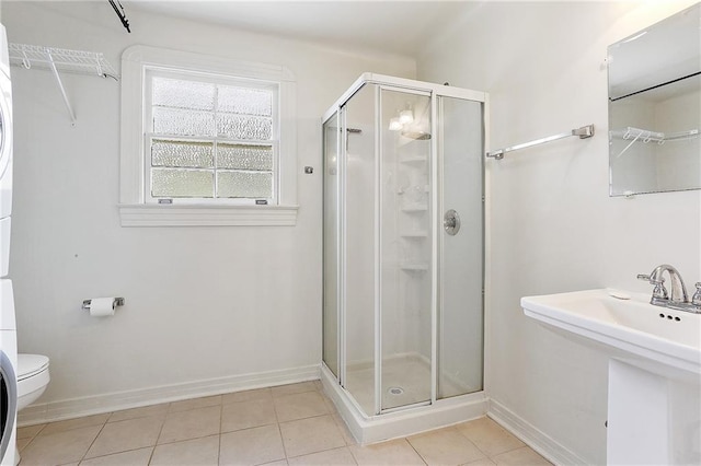 full bath featuring tile patterned floors, baseboards, toilet, and a stall shower