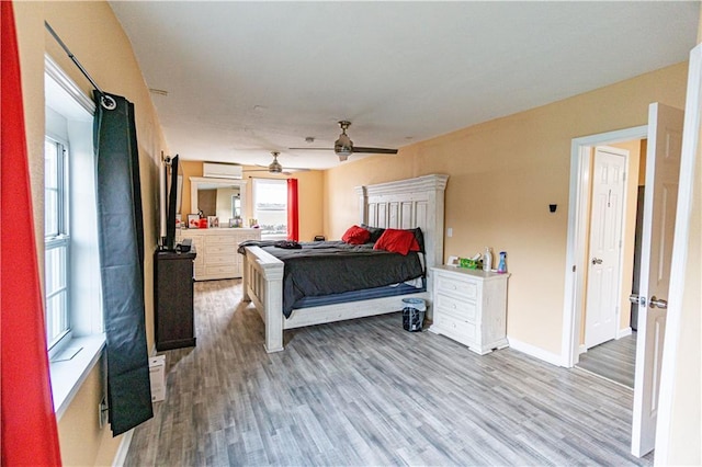 bedroom featuring wood finished floors, baseboards, and a ceiling fan