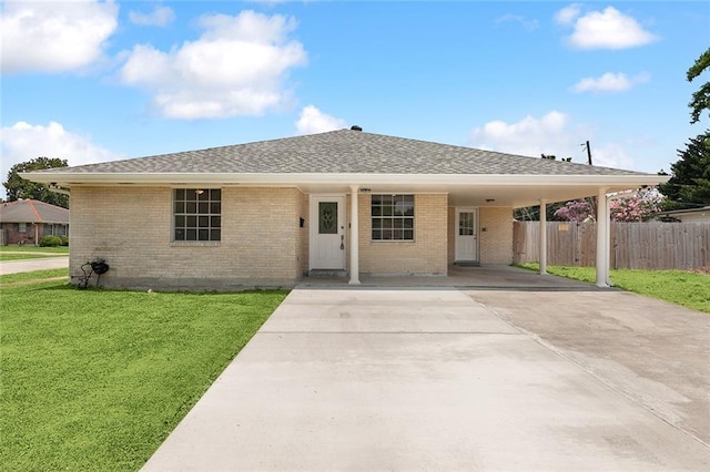 single story home featuring driveway, an attached carport, fence, a front yard, and brick siding