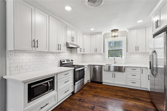 kitchen with visible vents, under cabinet range hood, a sink, dark wood finished floors, and stainless steel appliances