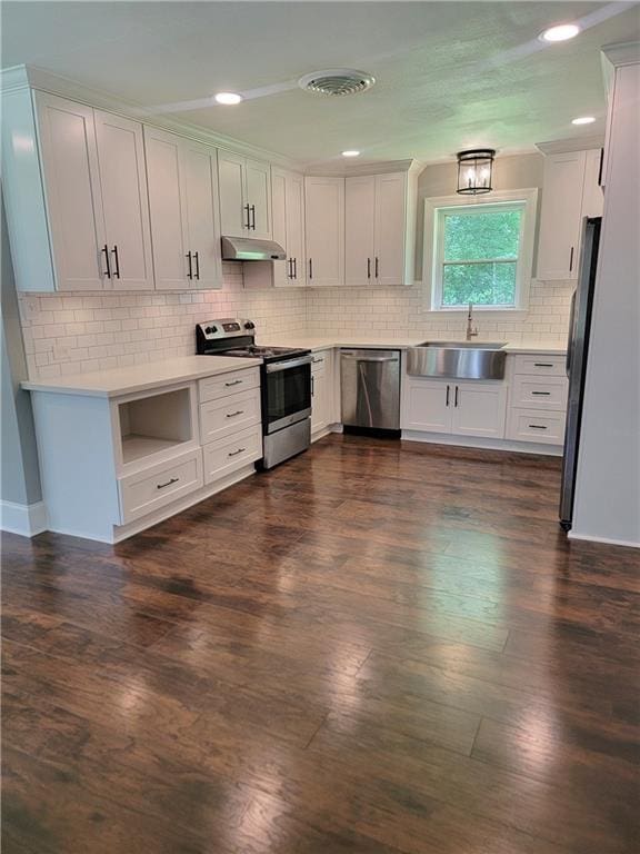 72462 Wilkinson St, Covington, LA 70435 - kitchen featuring stainless steel appliances, a sink, decorative backsplash, dark wood-style flooring, and recessed lighting