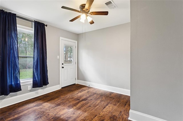 foyer entrance with a ceiling fan, plenty of natural light, wood finished floors, and baseboards