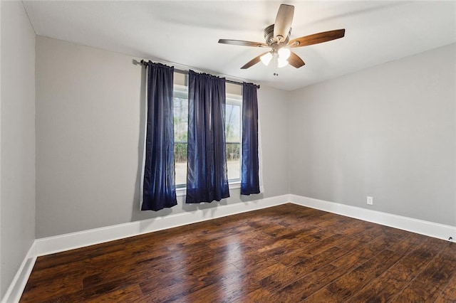 empty room with a ceiling fan, baseboards, and wood finished floors