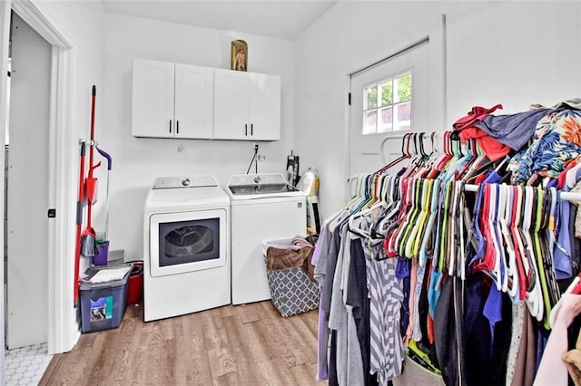 washroom featuring cabinet space, washer and dryer, and light wood-style floors