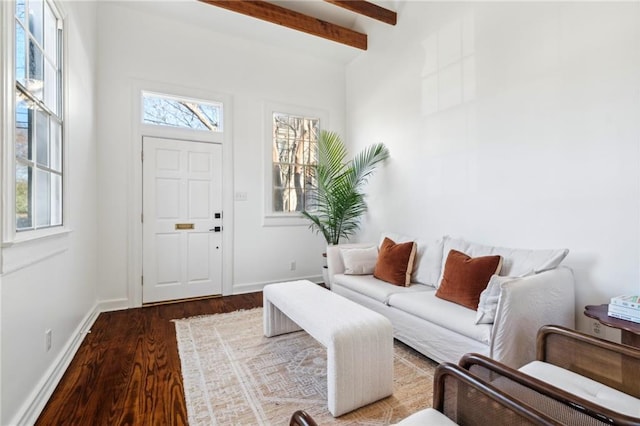 living area with beam ceiling, baseboards, and wood finished floors