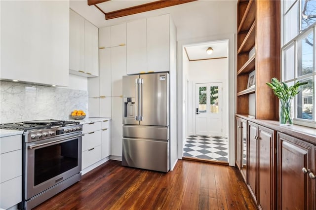 kitchen with dark wood-type flooring, light countertops, decorative backsplash, appliances with stainless steel finishes, and white cabinetry