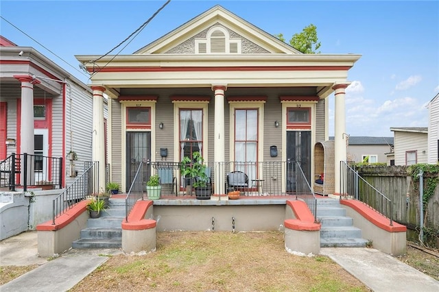 view of front facade featuring covered porch and fence