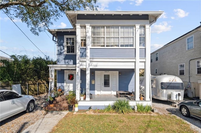 view of front of house featuring a porch, a front yard, and fence