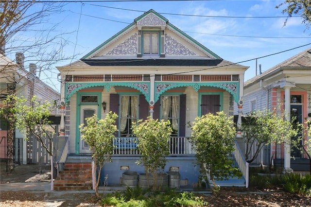 victorian house featuring brick siding and covered porch