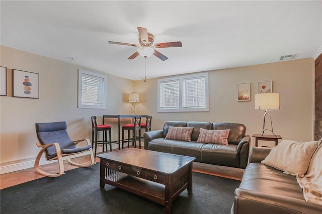 living room with visible vents, baseboards, and ceiling fan