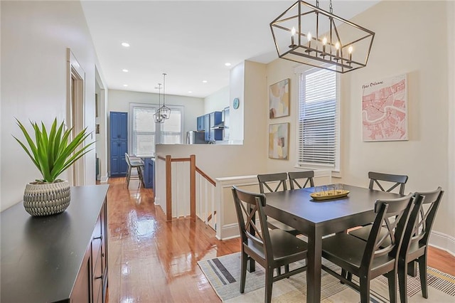 dining space with recessed lighting, light wood-type flooring, baseboards, and a chandelier