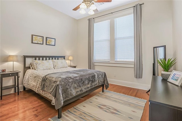 bedroom with ceiling fan, baseboards, and wood finished floors