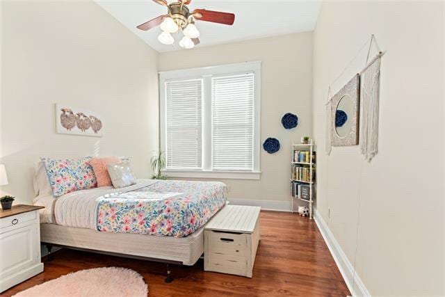 bedroom featuring vaulted ceiling, a ceiling fan, baseboards, and wood finished floors