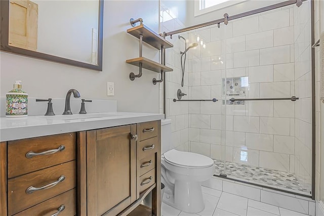 bathroom featuring tile patterned floors, a shower stall, toilet, and vanity