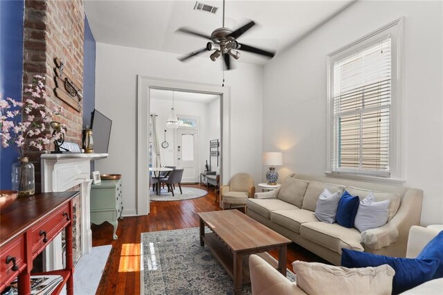 living area featuring visible vents, wood-type flooring, and a ceiling fan