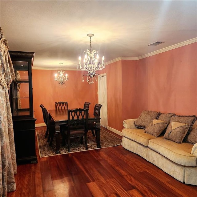 dining space featuring visible vents, an inviting chandelier, wood finished floors, and ornamental molding