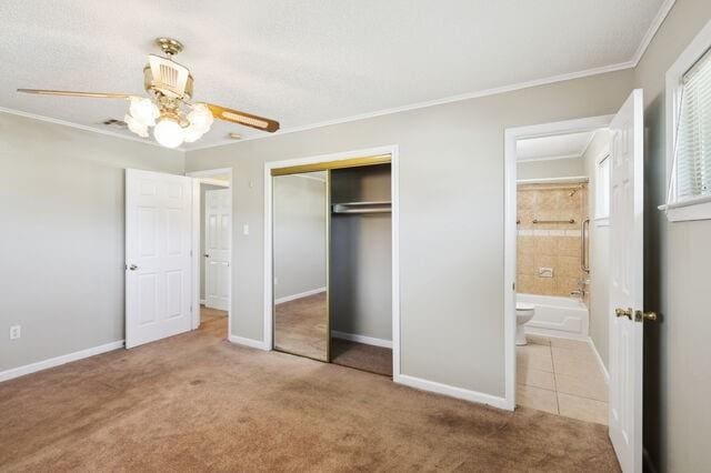 unfurnished bedroom featuring a closet, baseboards, carpet floors, and ornamental molding