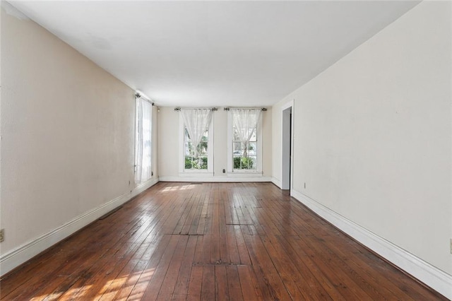 spare room with hardwood / wood-style flooring and baseboards