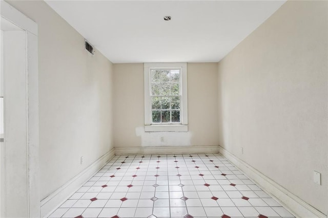 unfurnished room featuring light floors, visible vents, and baseboards