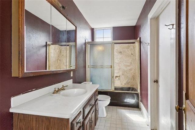 full bathroom featuring tile patterned floors, toilet, vanity, and bath / shower combo with glass door