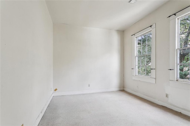 unfurnished room featuring plenty of natural light, baseboards, and carpet floors