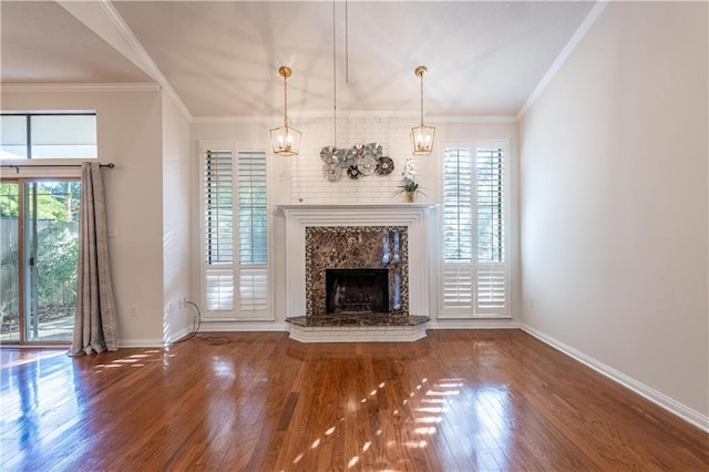 unfurnished living room with a fireplace, crown molding, wood finished floors, and baseboards