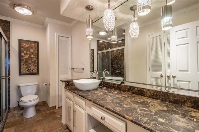 bathroom featuring vanity, a shower stall, toilet, and crown molding