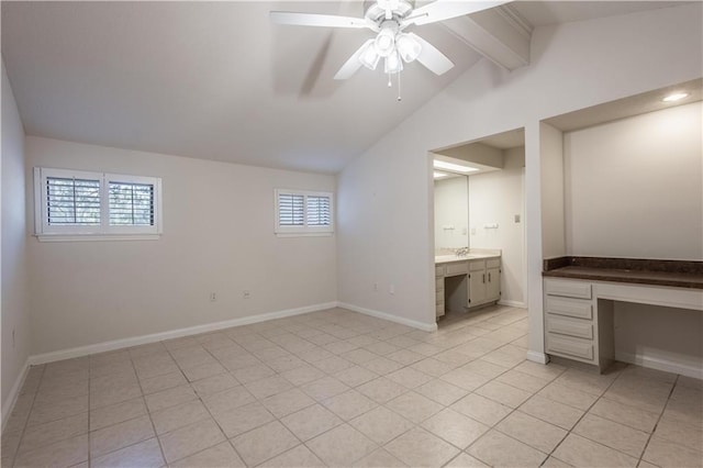 unfurnished bedroom featuring ceiling fan, baseboards, lofted ceiling with beams, light tile patterned floors, and built in study area