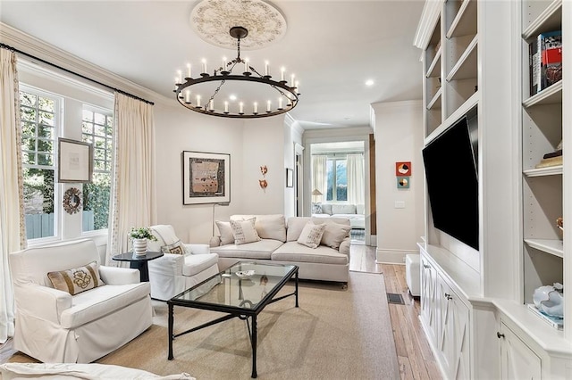 living room featuring light wood finished floors, crown molding, baseboards, recessed lighting, and an inviting chandelier