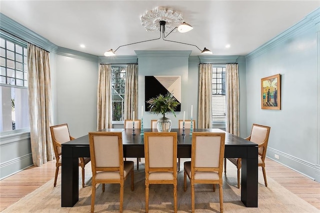 dining space with wood finished floors, a wealth of natural light, and ornamental molding