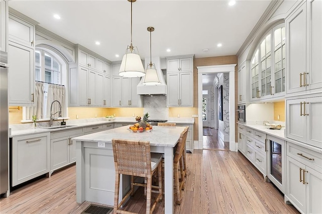 kitchen featuring oven, a sink, a center island, wine cooler, and custom exhaust hood