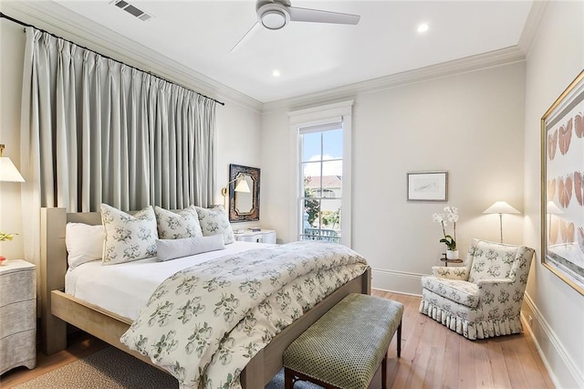 bedroom with visible vents, baseboards, light wood-style floors, and ornamental molding