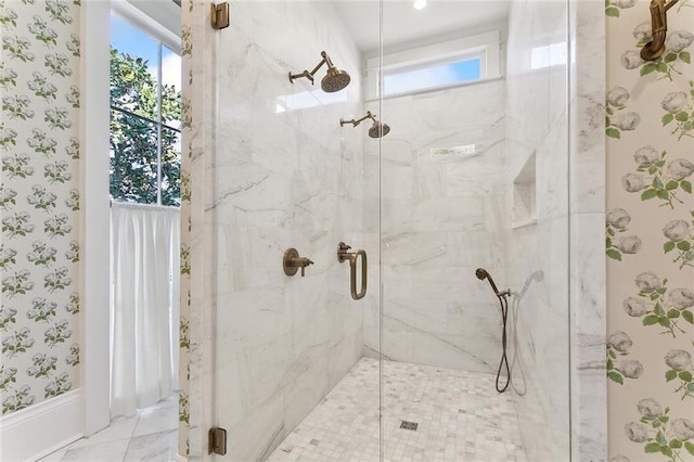 bathroom with wallpapered walls, a healthy amount of sunlight, marble finish floor, and a marble finish shower