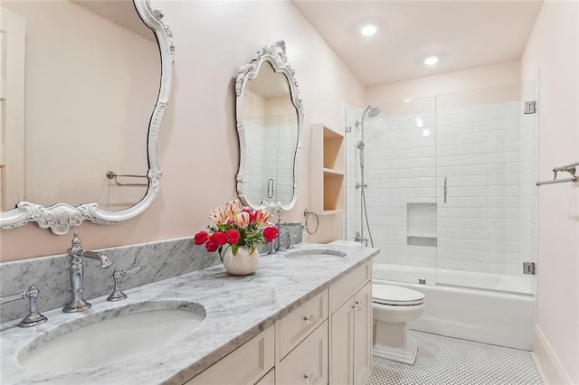 bathroom with tile patterned floors, combined bath / shower with glass door, toilet, and a sink