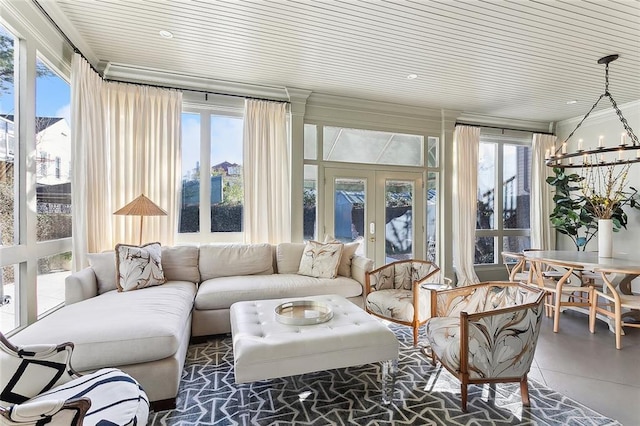 sunroom / solarium with french doors, a wealth of natural light, and a chandelier