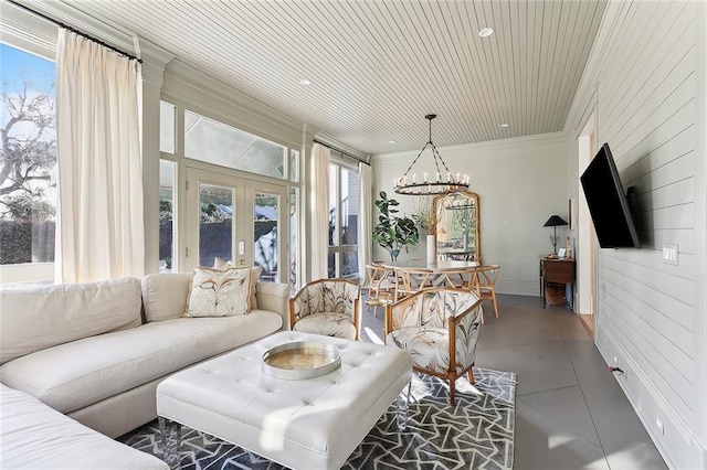 tiled living area with a notable chandelier, french doors, wood ceiling, and crown molding