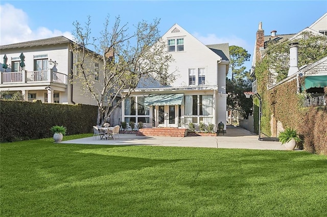 back of property featuring a patio area and a lawn