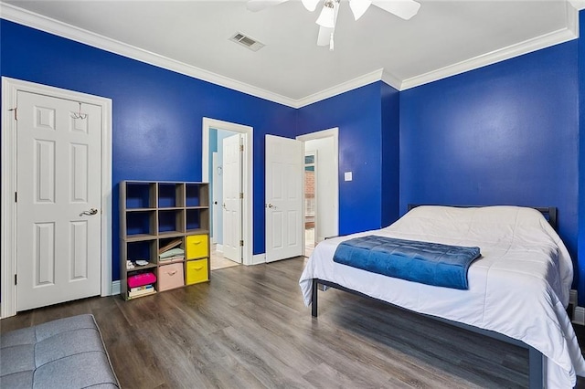 bedroom with a ceiling fan, wood finished floors, baseboards, ensuite bathroom, and crown molding