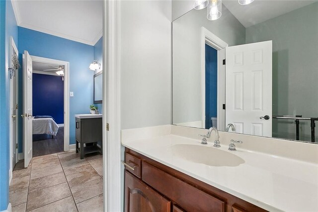 bathroom featuring tile patterned floors, ornamental molding, ensuite bath, baseboards, and vanity