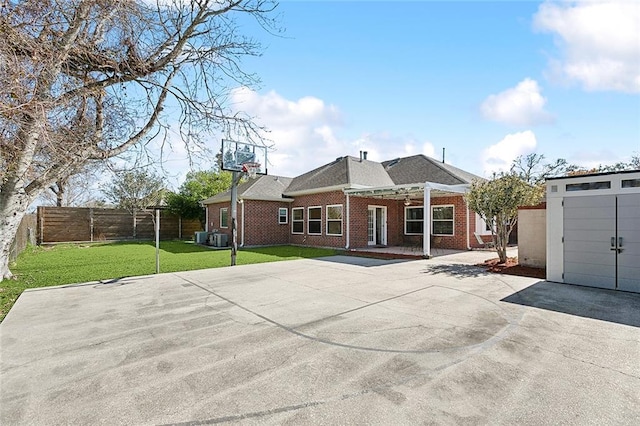 view of front facade with a front yard, a shed, a fenced backyard, an outdoor structure, and brick siding