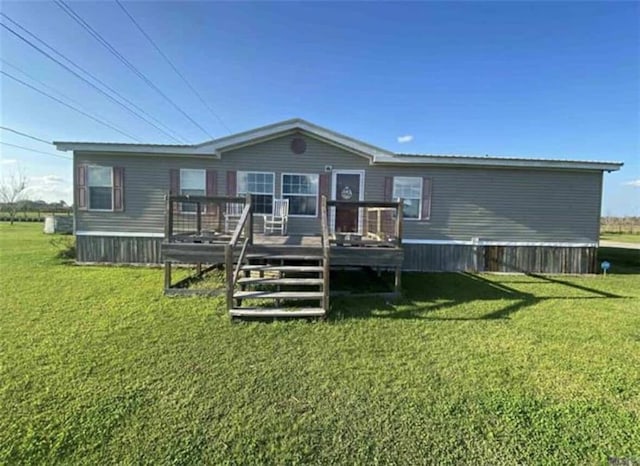 rear view of property featuring a deck and a yard