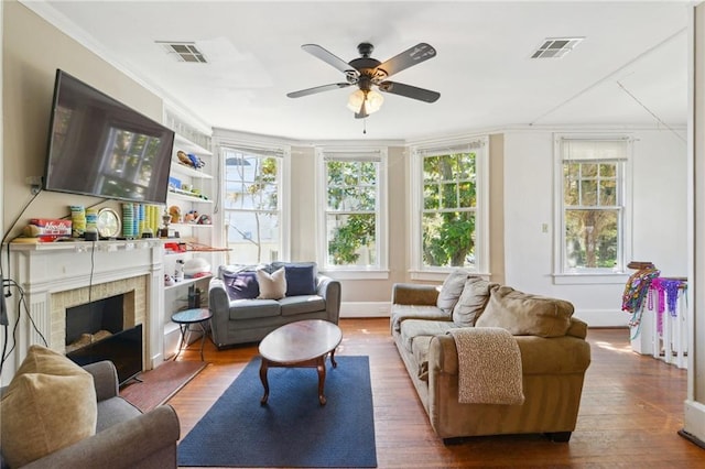 sunroom with visible vents, a fireplace with raised hearth, and a ceiling fan