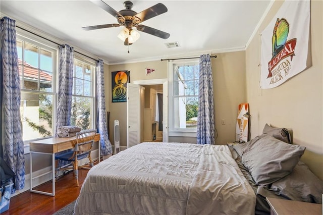 bedroom featuring visible vents, ceiling fan, baseboards, ornamental molding, and dark wood-style flooring