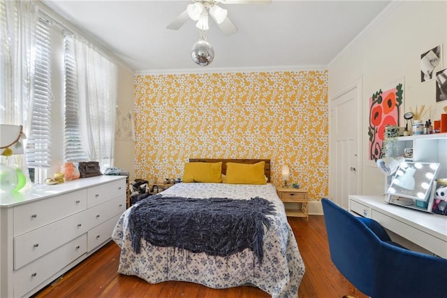 bedroom with wallpapered walls, crown molding, and wood finished floors