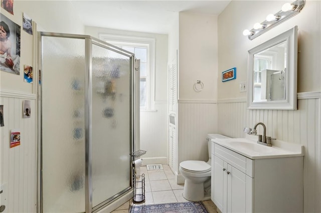 bathroom with tile patterned flooring, visible vents, a wainscoted wall, a stall shower, and vanity