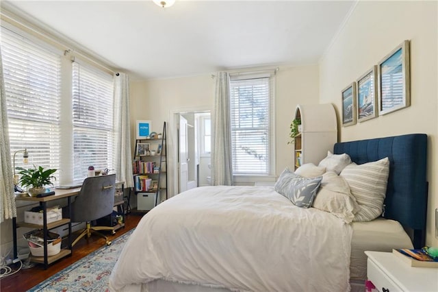 bedroom with wood finished floors and ornamental molding