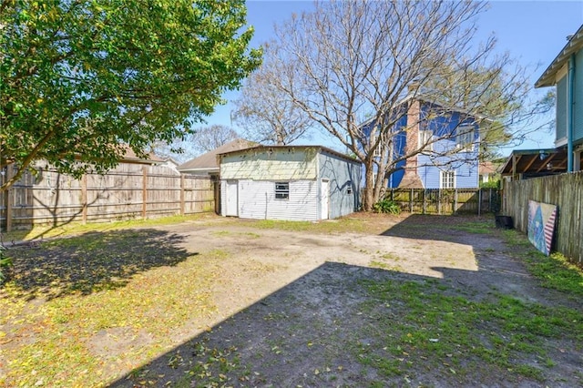 view of yard with a fenced backyard, a storage unit, and an outdoor structure