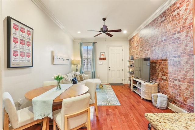 interior space featuring baseboards, light wood-style flooring, brick wall, and ornamental molding