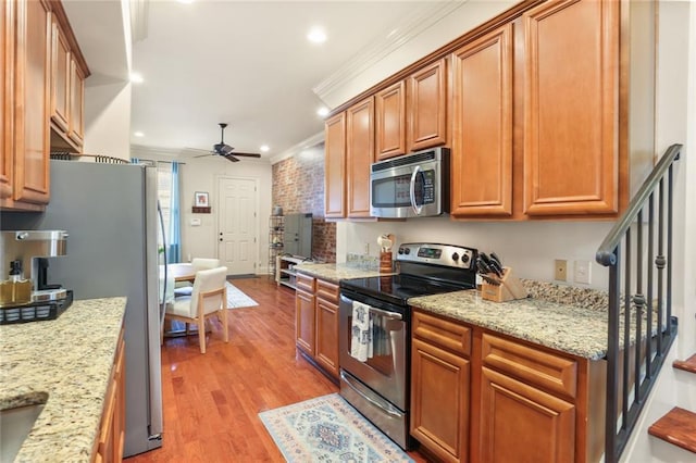 kitchen featuring ornamental molding, a ceiling fan, recessed lighting, stainless steel appliances, and light wood-style floors